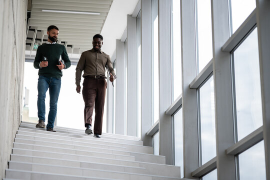 Business professional men walking downstairs in office building