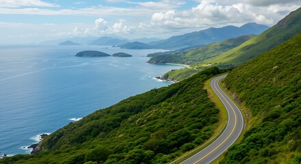 Scenic coastal road winding through lush green mountains with ocean view