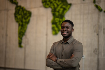 Confident black man standing against moss world map