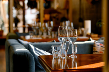 A table with clean glasses and goblets in the cozy interior of restaurant