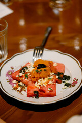 Summer watermelon salad with feta cheese, black olives and herbs