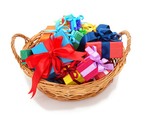Colorful gift boxes in wicker basket isolated on white background.