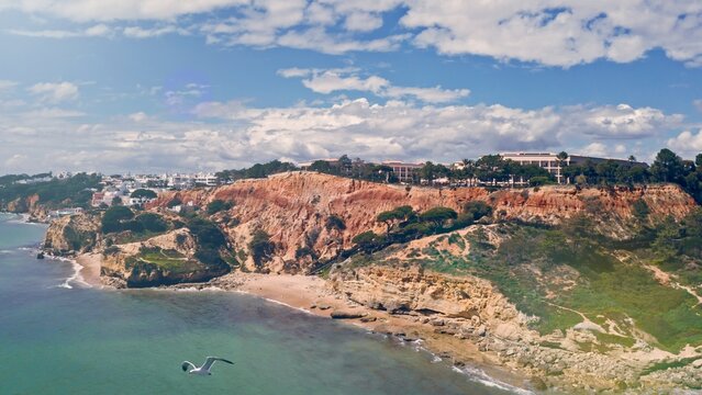 Aerial drone shot of Algarve resort historical province cliffs hills mountains exploring caves of Lagos South of Portugal travel adventure coastline Atlantic Ocean sandy beach clear blue water nature