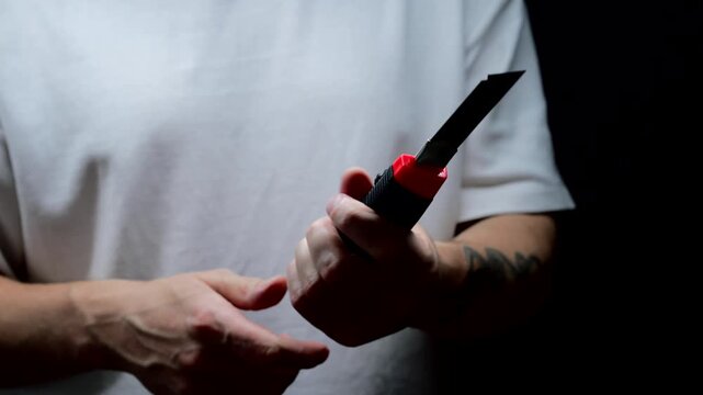 A man in a white T-shirt holds a retractable utility knife.
Retractable knife blade.
Knife, cutter, dangerous, blade, steel, equipment