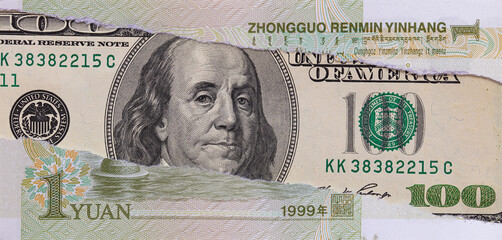 Torn Chinese Yuan Banknote Revealing US One Hundred Dollar Bill with Benjamin Franklin Portrait