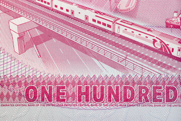 Extreme Macro Detail of New Polymer One Hundred UAE Dirham Banknote Showing High-Speed Train and Port Infrastructure