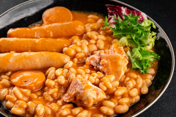 Casule meat with beans in sauce sausages, pork main course tasty snack fresh delicious gourmet food table background rustic food top view copy space