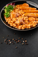 Casule meat with beans in sauce sausages, pork main course tasty snack fresh delicious gourmet food table background rustic food top view copy space