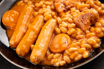 Casule meat with beans in sauce sausages, pork main course tasty snack fresh delicious gourmet food table background rustic food top view copy space
