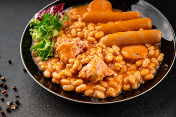 Casule meat with beans in sauce sausages, pork main course tasty snack fresh delicious gourmet food table background rustic food top view copy space