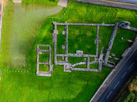 Top-down perspective of historic Tintern Abbey's stone foundations on vibrant green grass