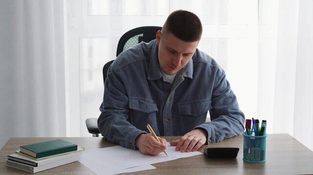 Filling out important documents with a pen.
A person writing something on a blank piece of paper.
Writing a letter.
A student preparing for exams.
Studying at a university.
A student with a pen.