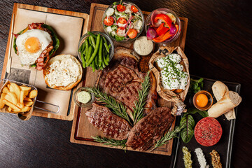 Grilled steak assortment served with fresh sides and herbs
Beef steaks on wooden boards with vegetables and sauces
Steak platter featuring ribeye and rustic garnishes