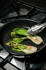 Fresh bok choy being cooked in a pan
Sautéed bok choy prepared as a simple vegetable dish
Pak choy greens cooking on a stovetop skillet
