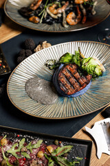 Gourmet grilled beef steak served with colorful puree
Premium steak medallion plated with greens and edible flower
Fine dining beef steak presented as an upscale entrée