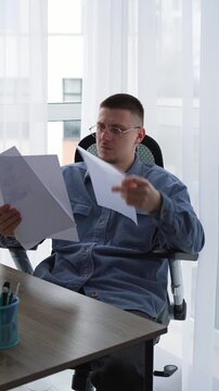 Documents on a businessman's desk.
The man is holding a stack of documents and reading them carefully.
Information on paper.
Paperwork in the HR department.
Resume, job, office, vacancy,