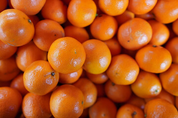 Fresh oranges piled high in a market, showcasing vibrant color and natural texture in a lively setting