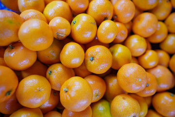 Fresh oranges piled high in a market stall ready for customers in the bright afternoon sun