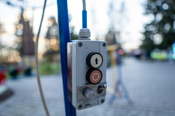 Control panel for a playground ride located in a community park during the late afternoon
