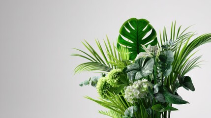 Vibrant arrangement of assorted green foliage occupies the right side against a neutral background