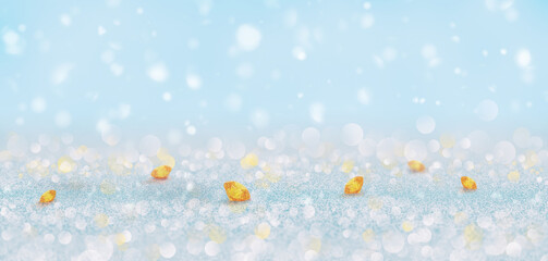 Sparkling winter background with scattered yellow gemstones on shimmering snow and soft bokeh lights, creating a festive and magical holiday atmosphere
