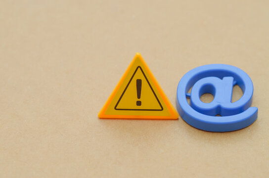 Digital Danger: Warning Symbol Intersects with Common Internet Icon, Highlighting Email Security Threats and the Critical Need for Online Caution.
