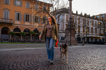 Woman and dog enjoying a stroll on a public square in an urban setting