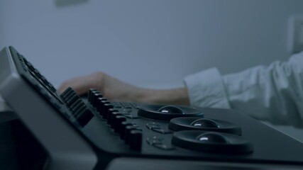 Close-up of a focused hand adjusting controls on a sleek audio device, showcasing intricate details and textures, with a gradual zoom emphasizing the precision of the action