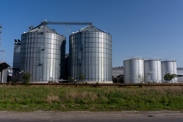 Industrial grain storage silos in a rural area on a clear day