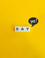 Say Yes Concept: Letter Tiles with Positive Speech Bubble on Yellow Background