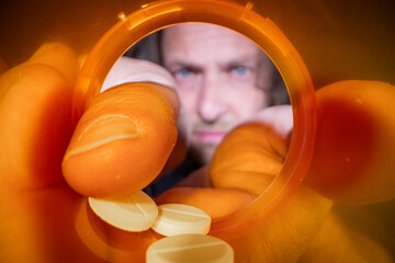 A powerful macro shot looking up from the inside of an empty, bright orange prescription pill...