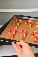 Step-by-step preparation of Candy Cane shortbread cookies in Christmas decor on a light concrete background. Merry Christmas!