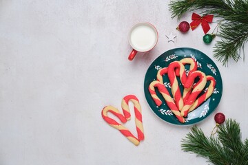 Christmas candy cane shortbread cookies on a green plate with Christmas decor against a white concrete background. Merry Christmas.