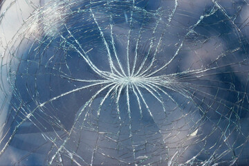 Radial starburst crack pattern on shattered glass