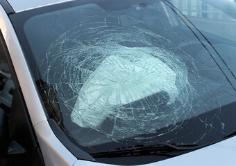 Broken car windshield with deployed airbag