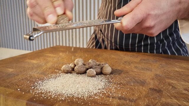 spice grater in cozy kitchen, artisan chocolatier carefully shredding nutmeg onto cookie sheet