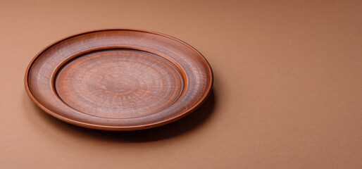 An empty round ceramic plate on a table, kitchenware. An empty plate