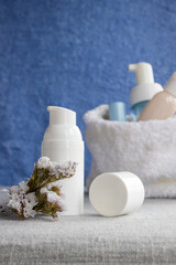 White pump bottle and cosmetic container with dried flowers, representing a skincare routine, beauty treatment, and self care ritual for wellness and relaxation