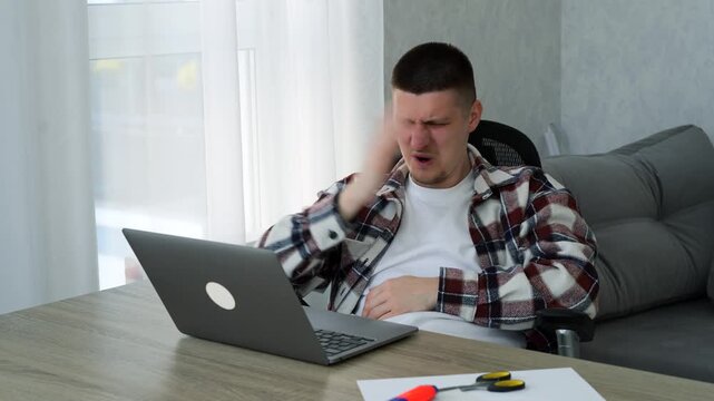 A young man has an unpleasant armpit odor.
The man is sweating and sniffing his armpits.
A sweaty man at his desk in an office.
Work, sweat, hygiene, disinfection, heat, dirty