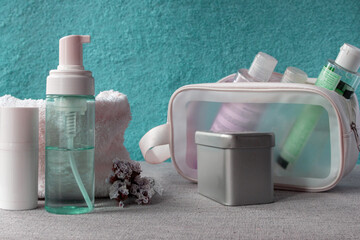 Organizing beauty and skincare products for a refreshing self care regimen, packing essential toiletries into a clear travel bag for hygiene and personal wellness