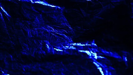 A captivating textured background featuring shimmering blue foil with intricate patterns illuminated by light creating a dynamic visual effect that conveys a modern and artistic aesthetic
