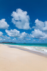 Fototapeta premium Waimānalo Beach Park, Honolulu, Windward Coast Oahu, Hawaii. Pacific Ocean. Cumulus clouds are clouds that have flat bases and are often described as puffy, cotton-like, or fluffy in appearance. 
