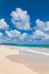 Fototapeta premium Waimānalo Beach Park, Honolulu, Windward Coast Oahu, Hawaii. Pacific Ocean. Cumulus clouds are clouds that have flat bases and are often described as puffy, cotton-like, or fluffy in appearance. 