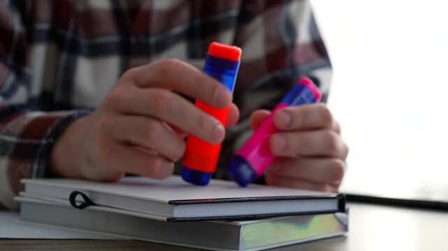 A young man holds a pink highlighter while sitting at his desk in an office.
Important information in documents.
Highlighter, office, desk, paperwork, business, texting, typing