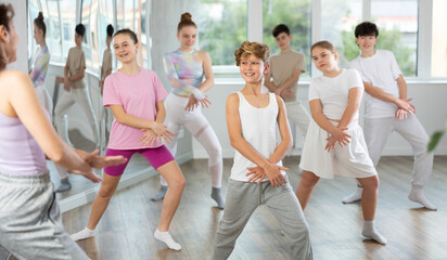 Teenage boy rehearse hip hop dance repeats movements of unrecognizable instructor performance with peers. Preparing for performance of choreographic team, practicing skills, repeating exercises