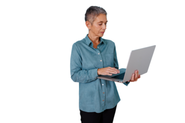 Senior woman standing, focused on her laptop screen, actively typing on the keyboard. Transparent background