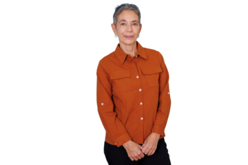 Senior woman with short grey hair standing, smiling at the camera, wearing an orange casual shirt on transparent background