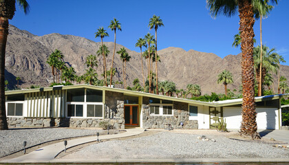 Mid-century modern house in Palm Springs with palm trees and mountains © matt