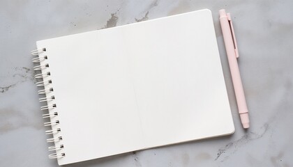 Blank notebook with pink pen on marble surface for creativity  