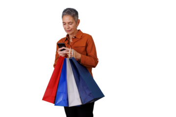 Senior woman shopping, carrying colorful paper bags and browsing social media or apps on her smartphone. Transparent background